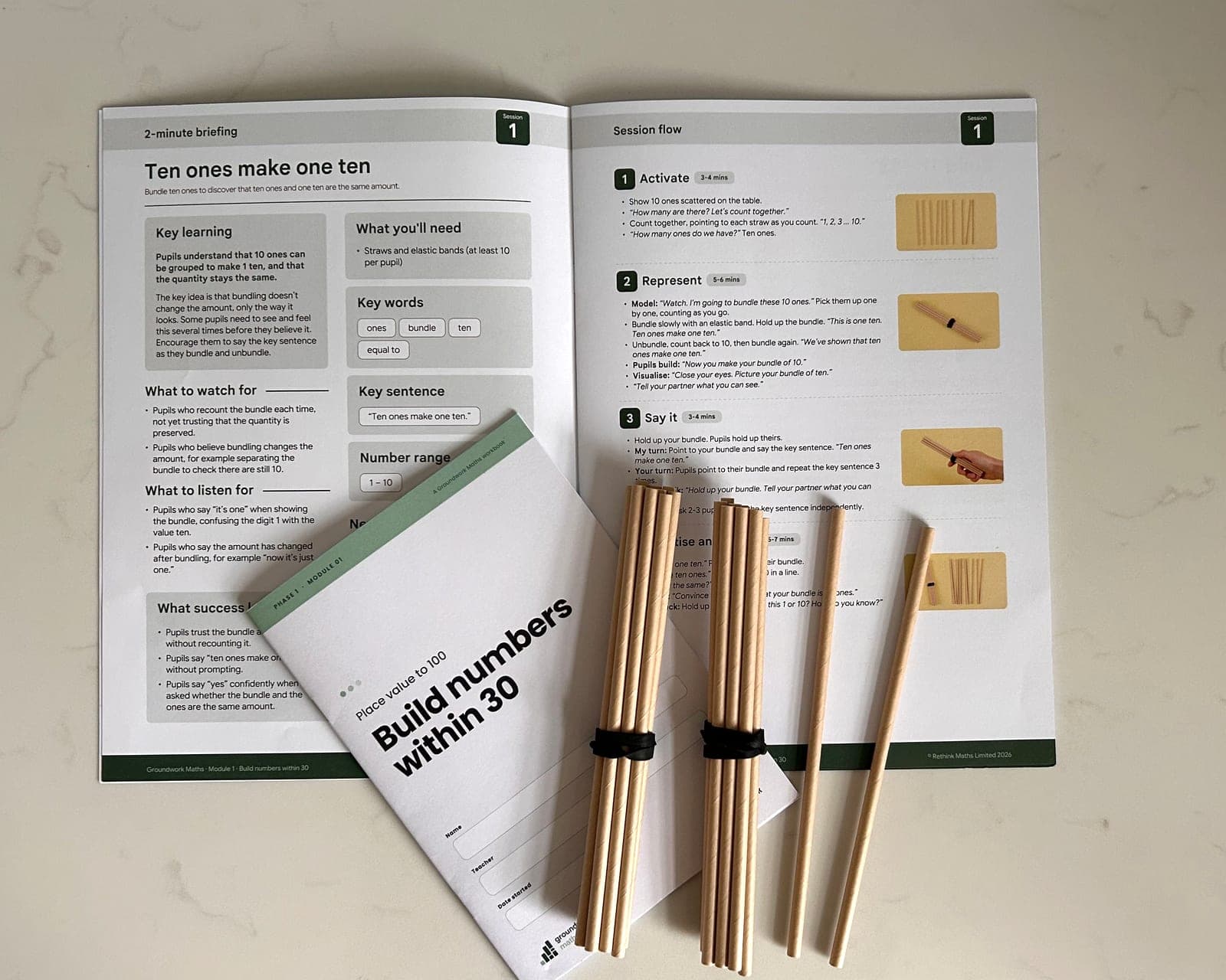 An open Groundwork Maths teaching guide and student workbook, with bundles of straws, showing the contents of a phase pack.