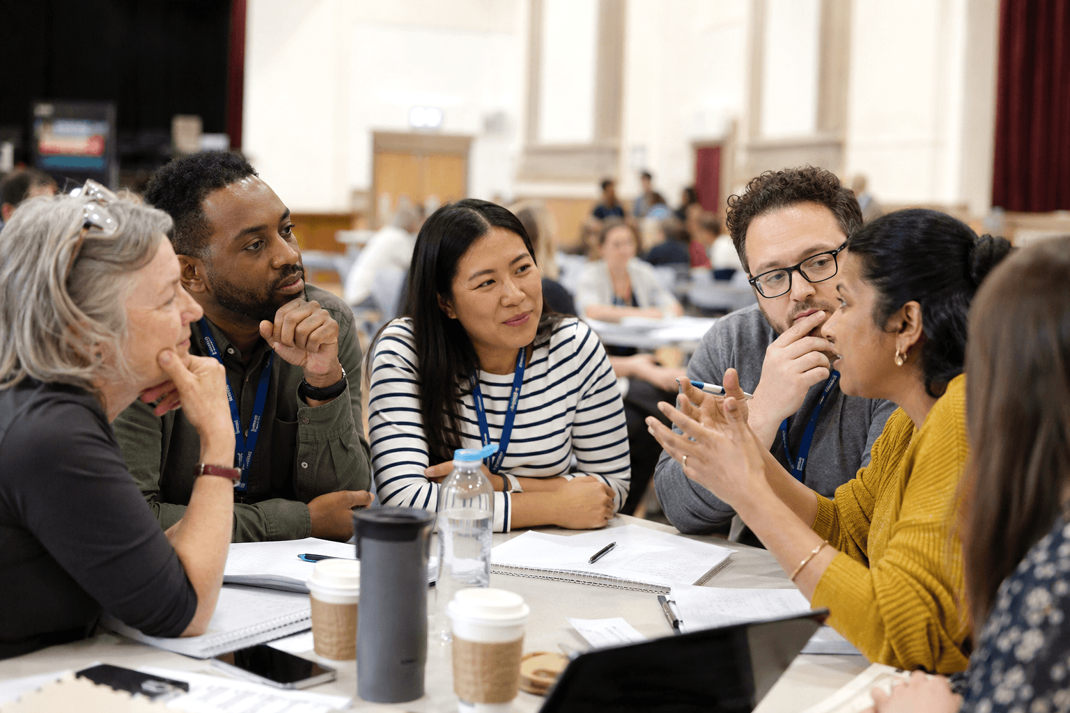 Teachers in discussion around a table during a face-to-face training session